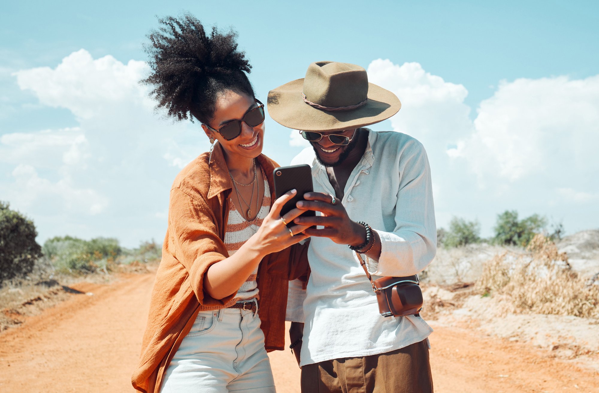 black-couple-with-phone-travel-adventure-happy-outdoors-outback-australia-during-summer-vacation-romantic-bonding-roadtrip-smile-search-map-mobile-app-internet